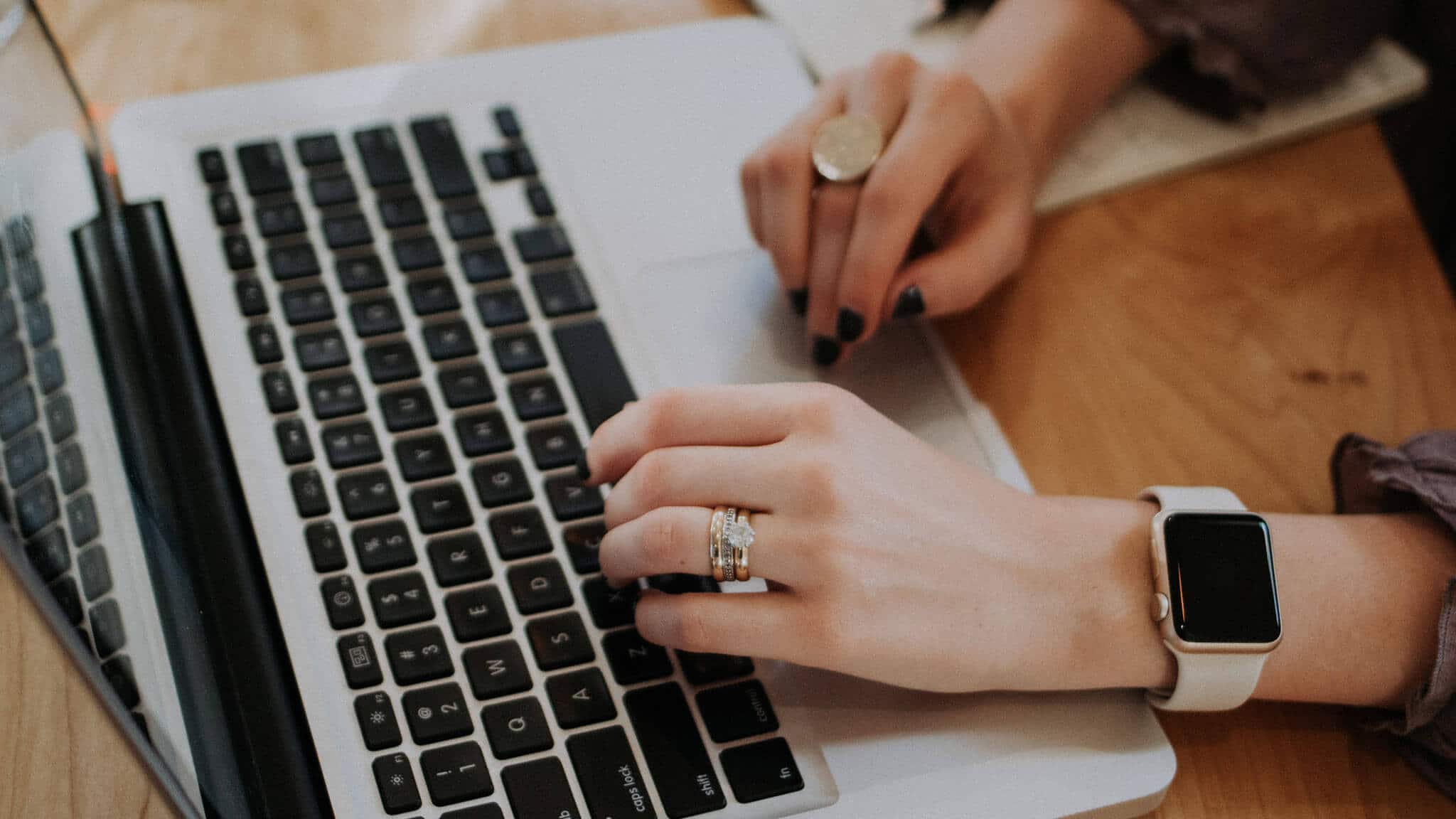 Close up of woman's hands typing on a laptop