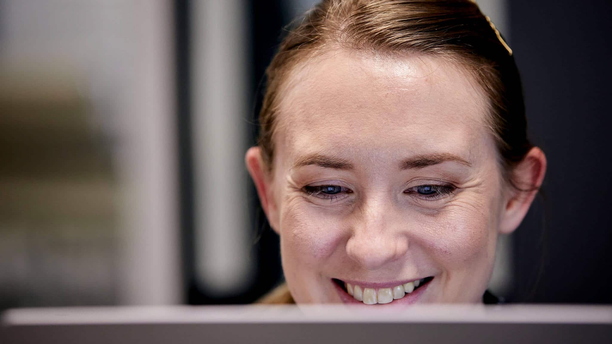 Close up of smiling woman's face behind screen