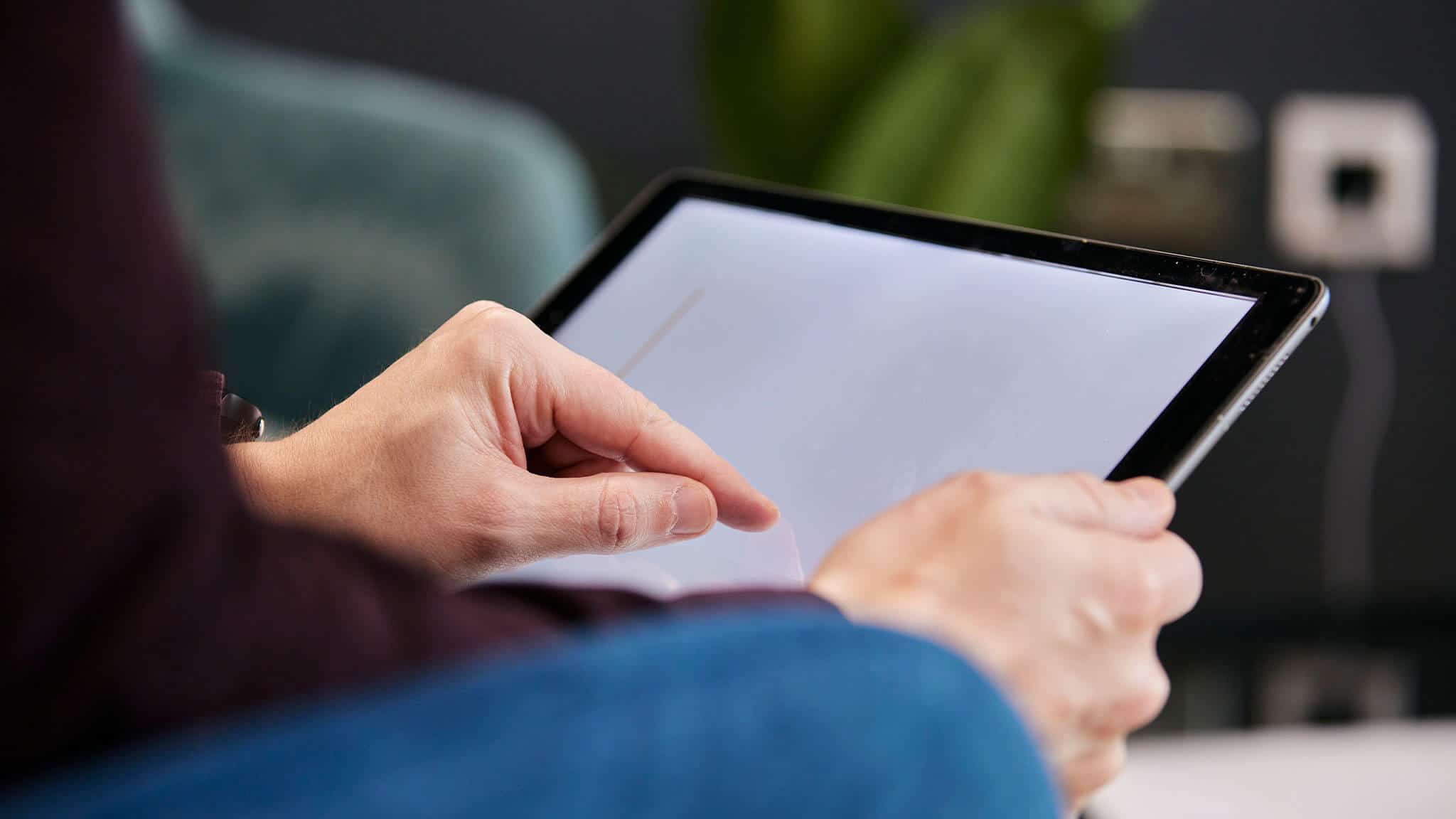 close up of a man's hands operating a tablet